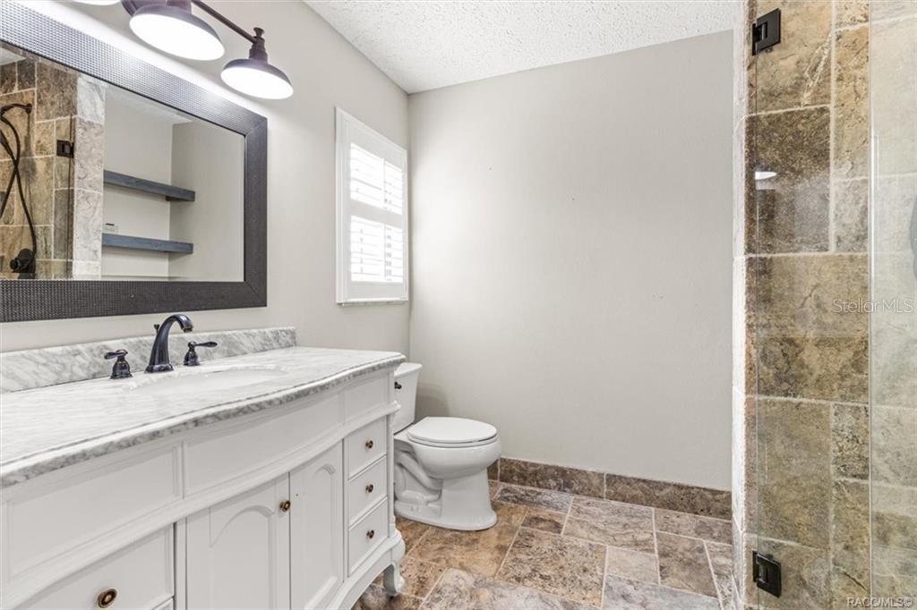 8801 East Cresco Lane Inverness, FL 34450 - Photo 25 of 51 a bathroom with a granite countertop sink a toilet and a mirror