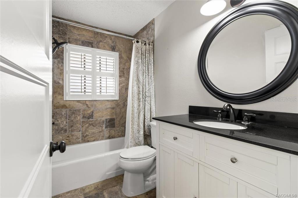 8801 East Cresco Lane Inverness, FL 34450 - Photo 26 of 51 a bathroom with a granite countertop toilet a sink and a mirror