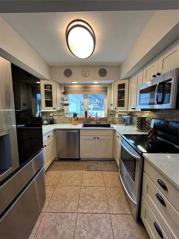 8801 East Cresco Lane Inverness, FL 34450 - Photo 29 of 51 a kitchen with stainless steel appliances granite countertop a sink a stove top oven a counter space cabinets and a window