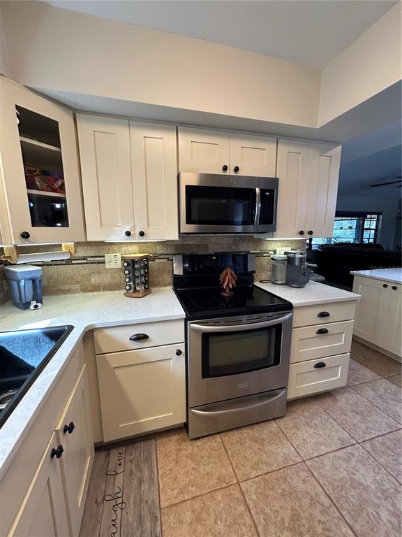 8801 East Cresco Lane Inverness, FL 34450 - Photo 30 of 51 a kitchen with stainless steel appliances a stove sink microwave and cabinets