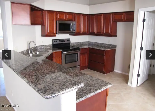 a kitchen with granite countertop a sink stove and refrigerator