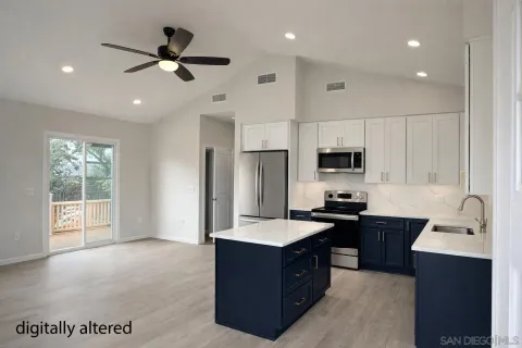 a kitchen with stainless steel appliances kitchen island granite countertop a refrigerator and a sink
