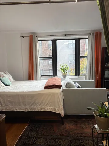 a living room with a large window and a bed