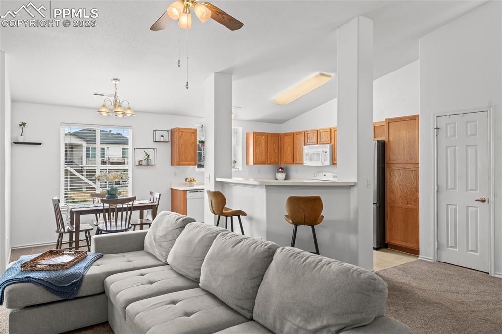 3976 Riviera Grove, Unit 203 Colorado Springs, CO 80922 - Photo 5 of 45 a living room with furniture and a chandelier