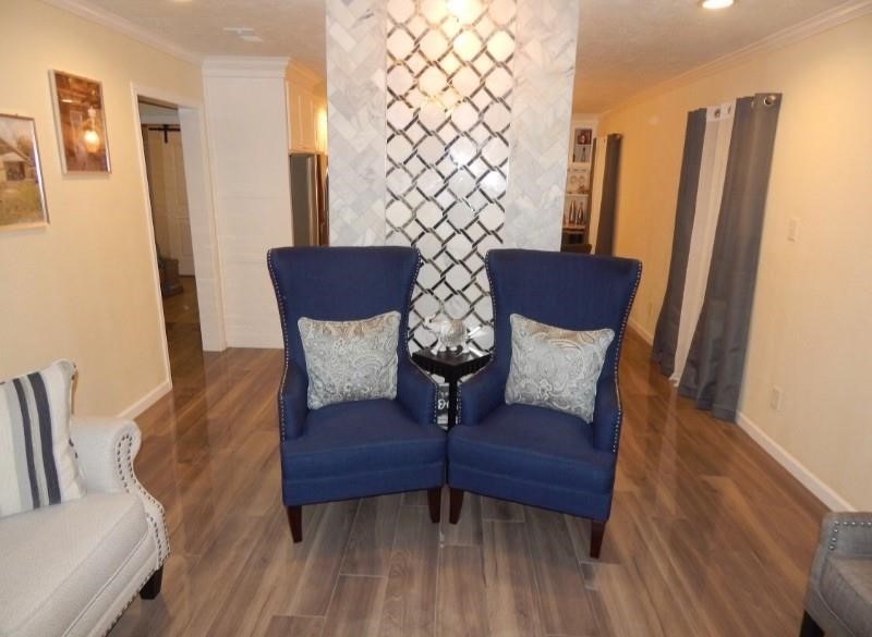 a view of a living room with furniture and wooden floor