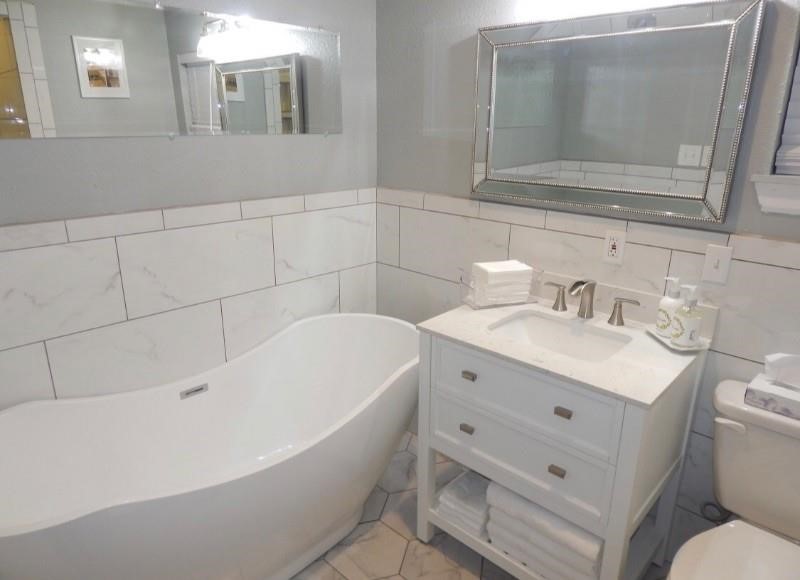 8821 Woodruff Street Houston, TX 77012 - Photo 14 of 20 a bathroom with a sink mirror vanity and toilet
