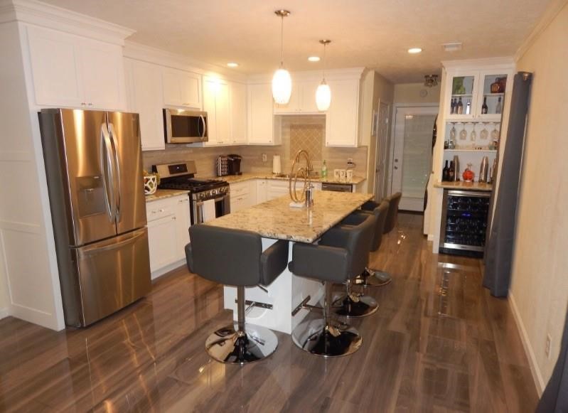 8821 Woodruff Street Houston, TX 77012 - Photo 4 of 20 a kitchen with stainless steel appliances granite countertop a refrigerator a stove a sink dishwasher and a dining table with wooden floor