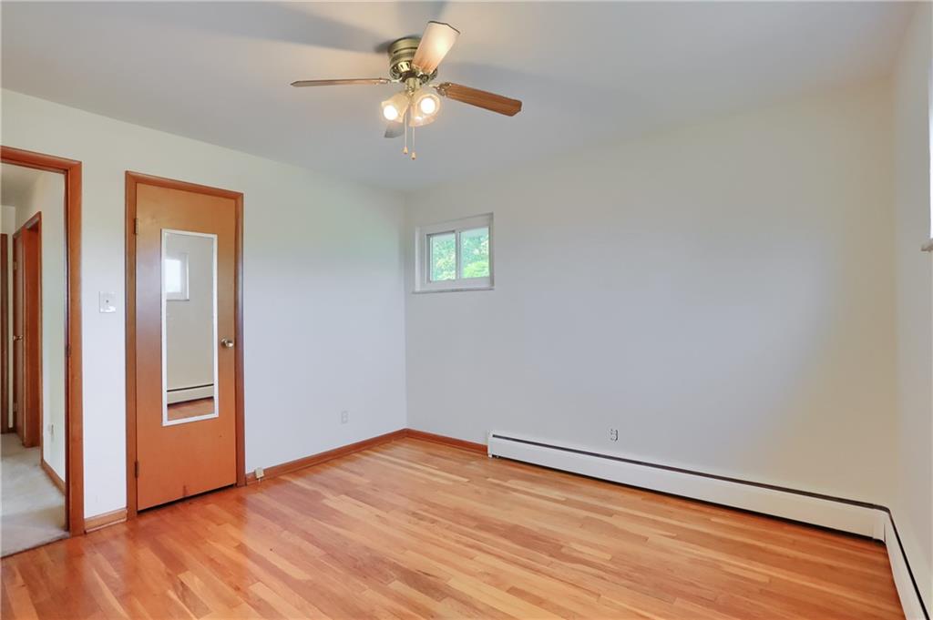 104 Linda Vista Road Sewickley, PA 15143 - Photo 13 of 50 an empty room with wooden floor chandelier fan and windows