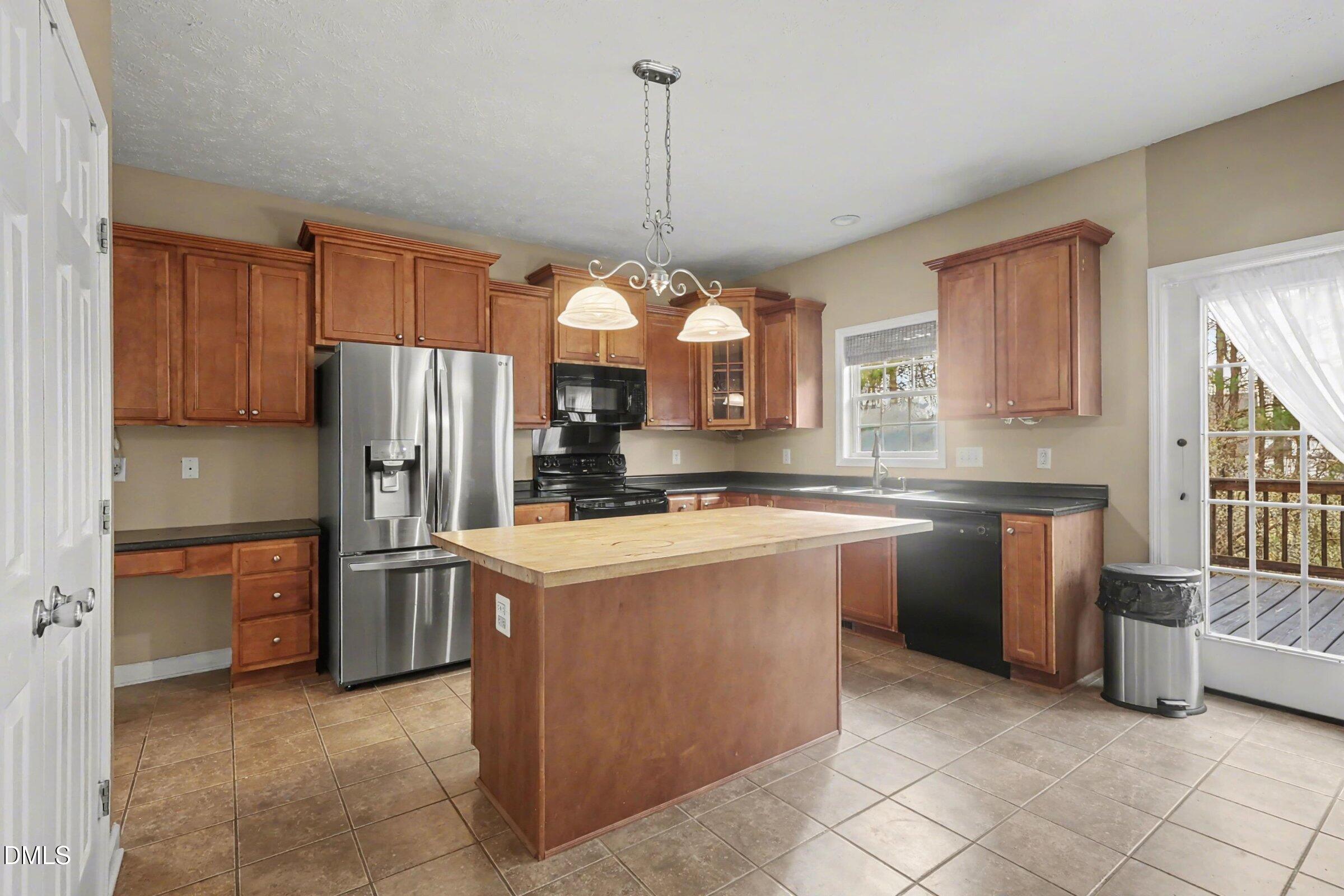 615 Lenoir Drive Spring Lake, NC 28390 - Photo 11 of 39 a kitchen with stainless steel appliances granite countertop a refrigerator a sink a stove and white cabinets