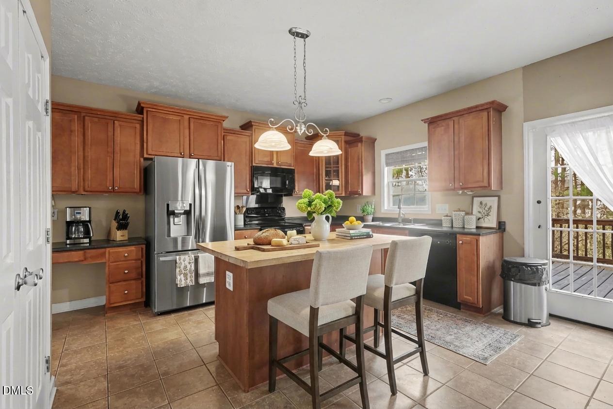 615 Lenoir Drive Spring Lake, NC 28390 - Photo 12 of 39 a kitchen that has a refrigerator a stove a sink and a dining table with wooden floor