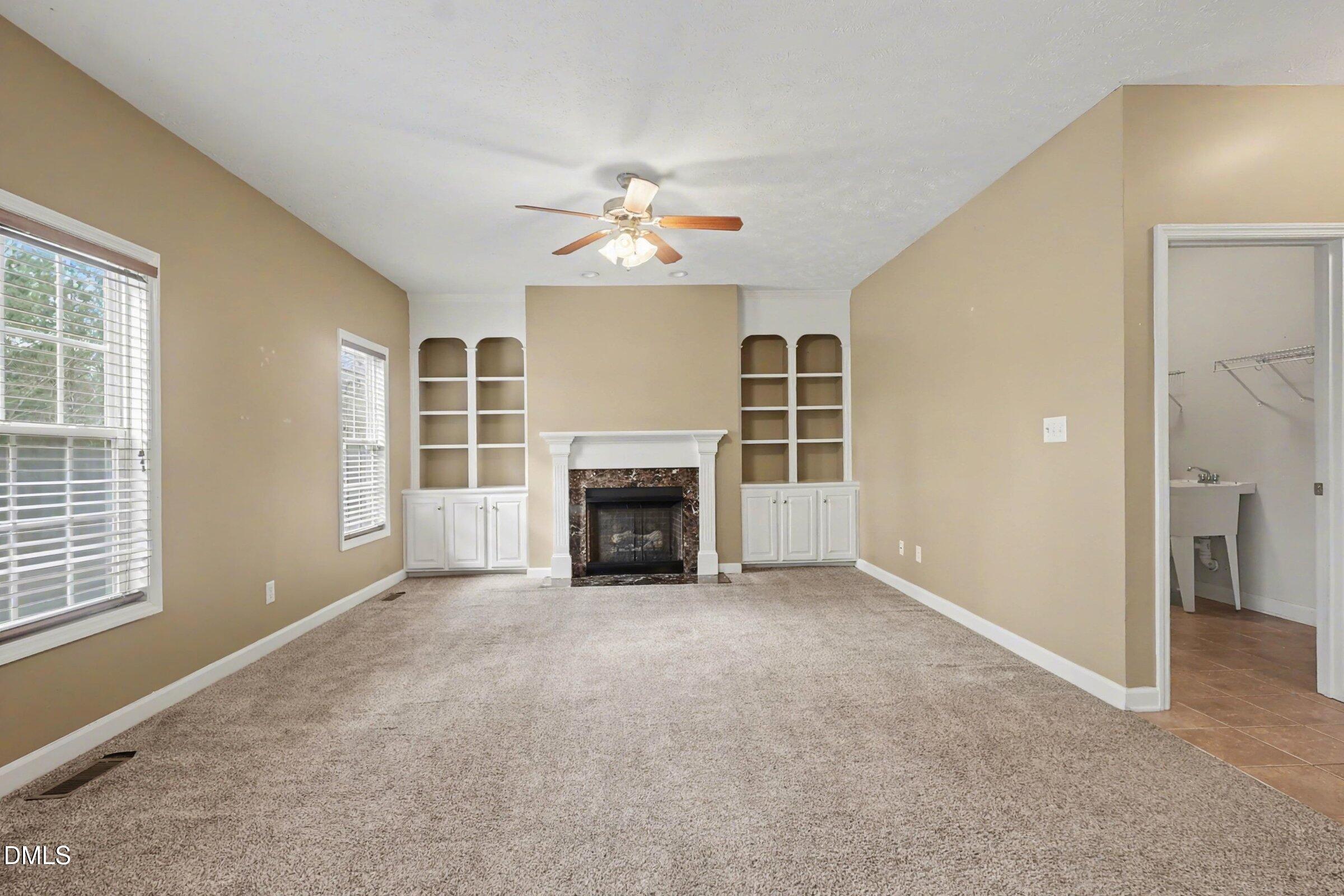 615 Lenoir Drive Spring Lake, NC 28390 - Photo 15 of 39 an empty room with windows fireplace and fan