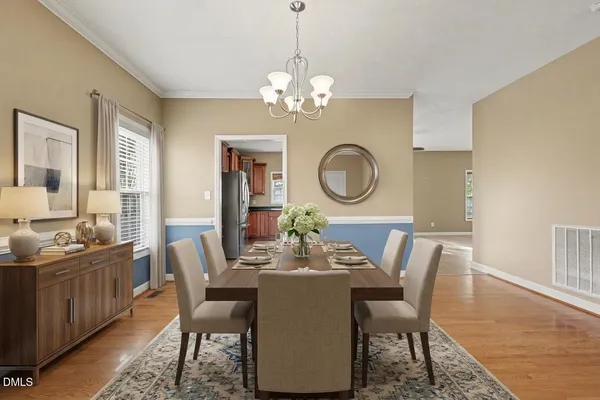 a dining room with furniture a chandelier and wooden floor