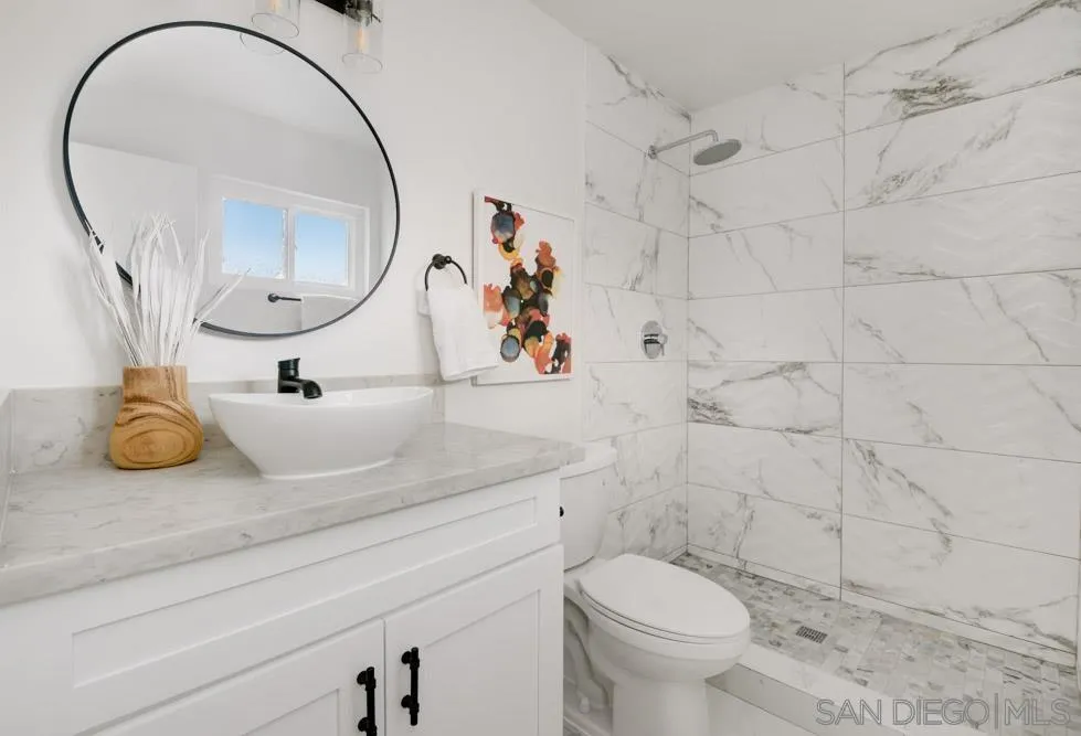9428 Leticia Drive Santee, CA 92071 - Photo 11 of 17 a bathroom with a toilet a sink and mirror