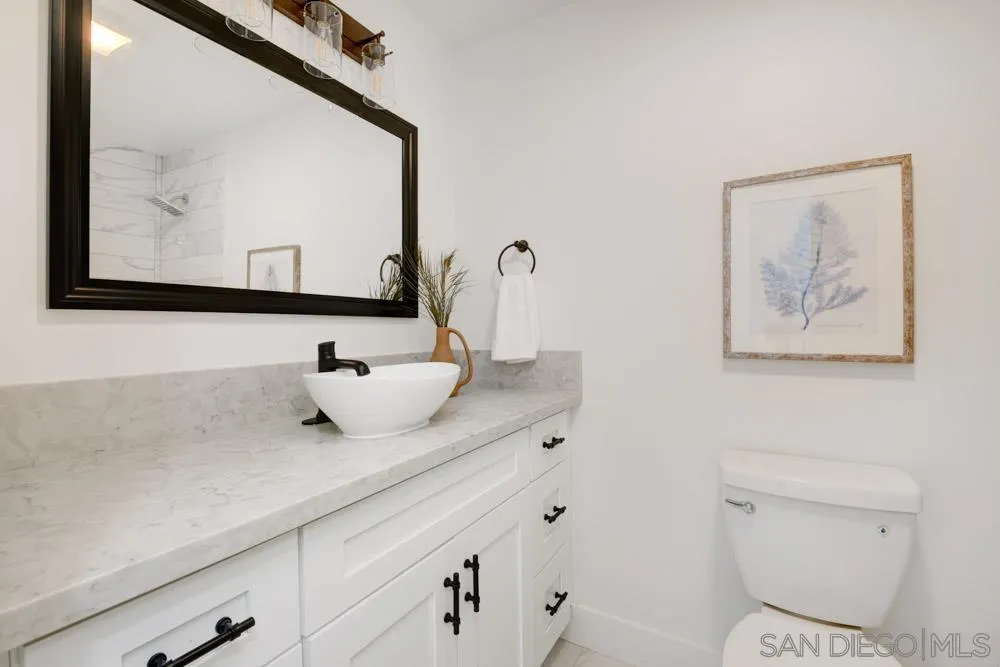 9428 Leticia Drive Santee, CA 92071 - Photo 12 of 17 a bathroom with a toilet sink and mirror