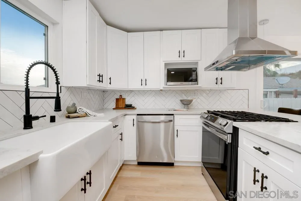 9428 Leticia Drive Santee, CA 92071 - Photo 8 of 17 a kitchen with stainless steel appliances granite countertop a stove a sink and a microwave