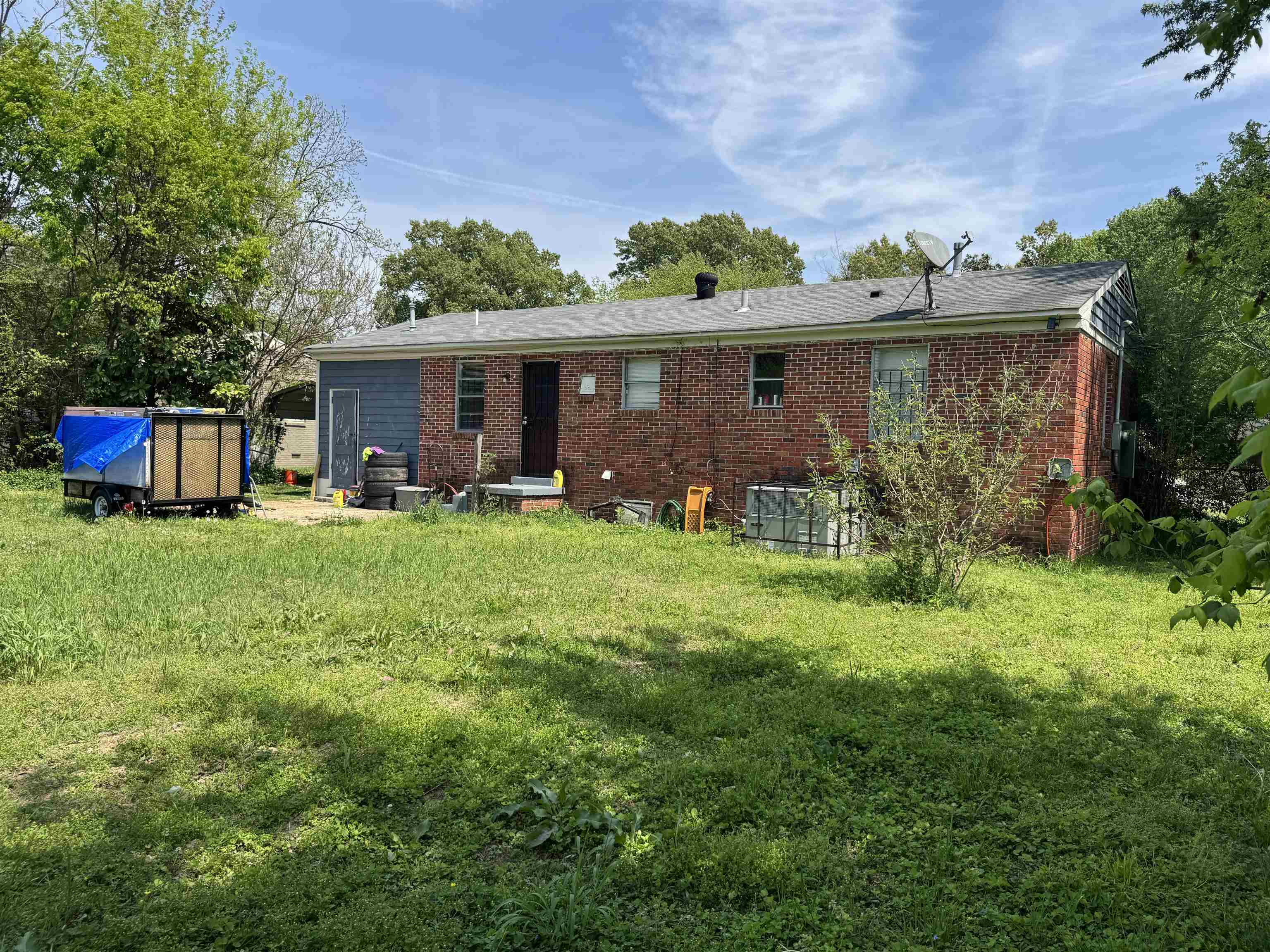 Back of house featuring a yard and brick siding
