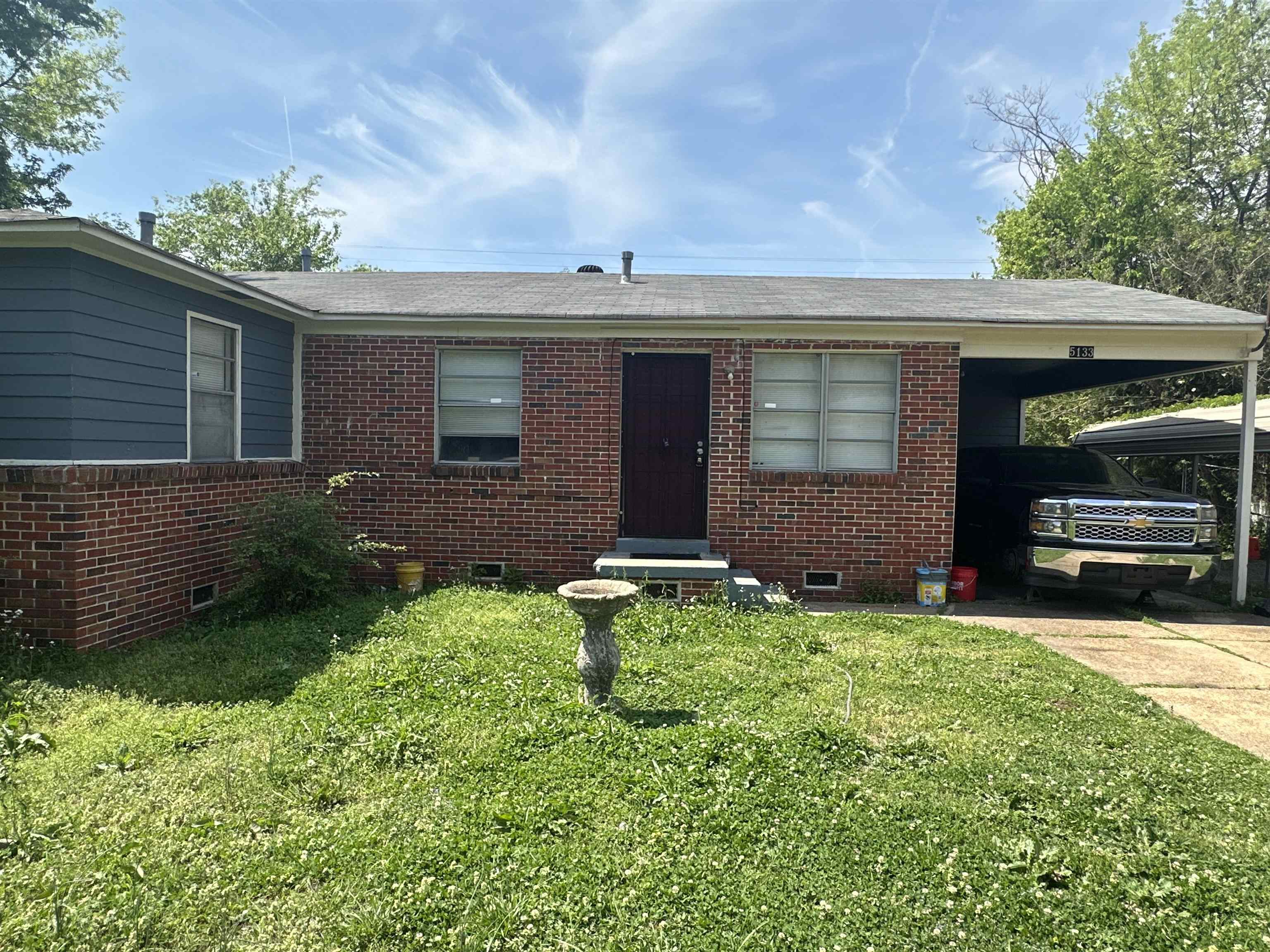 5133 Stacey Road Memphis, TN 38109 - Photo 2 of 10 Ranch-style house featuring crawl space, brick siding, a front lawn, and an attached carport
