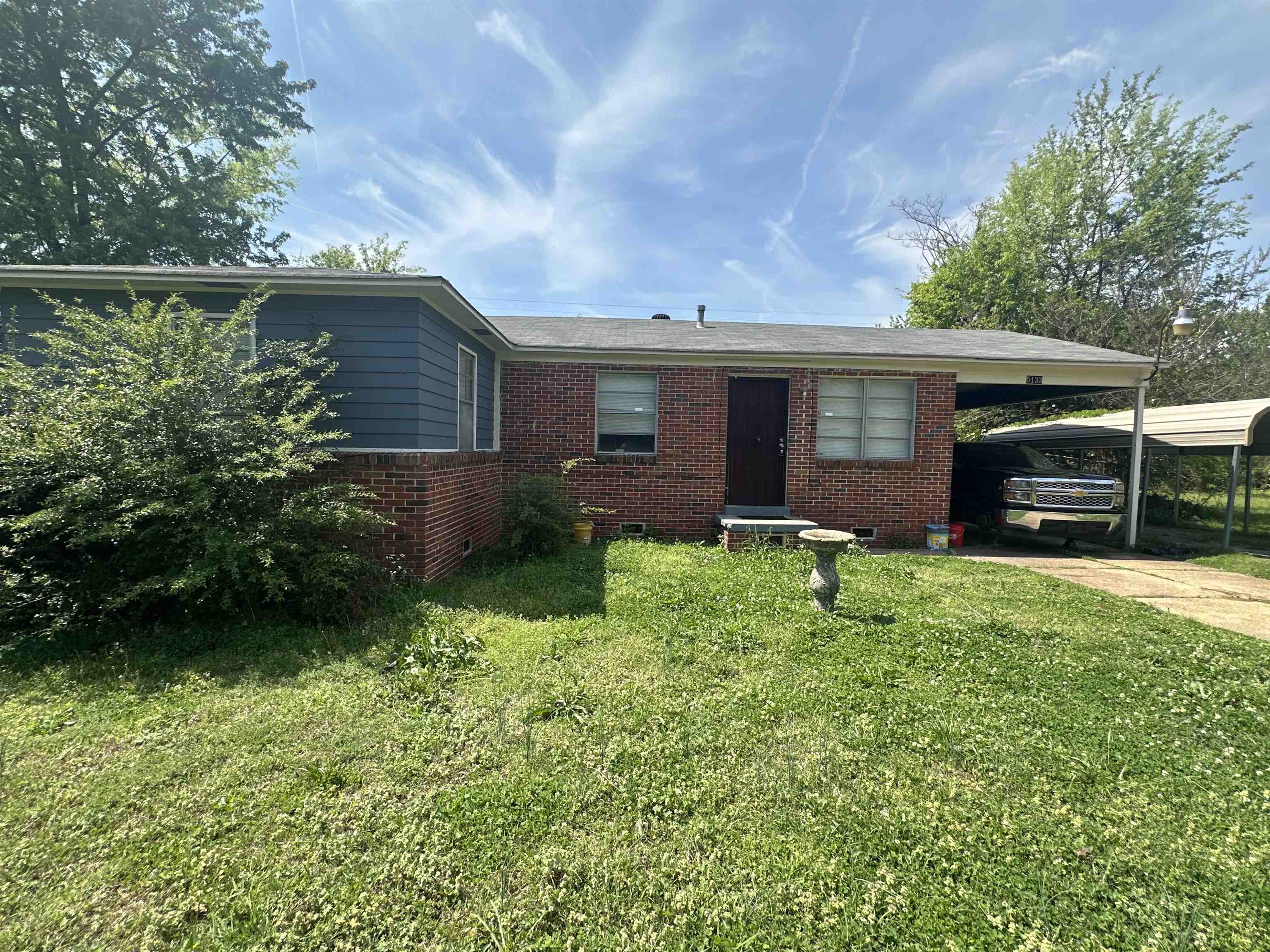 5133 Stacey Road Memphis, TN 38109 - Photo 5 of 10 Single story home with brick siding, a front yard, an attached carport, and concrete driveway