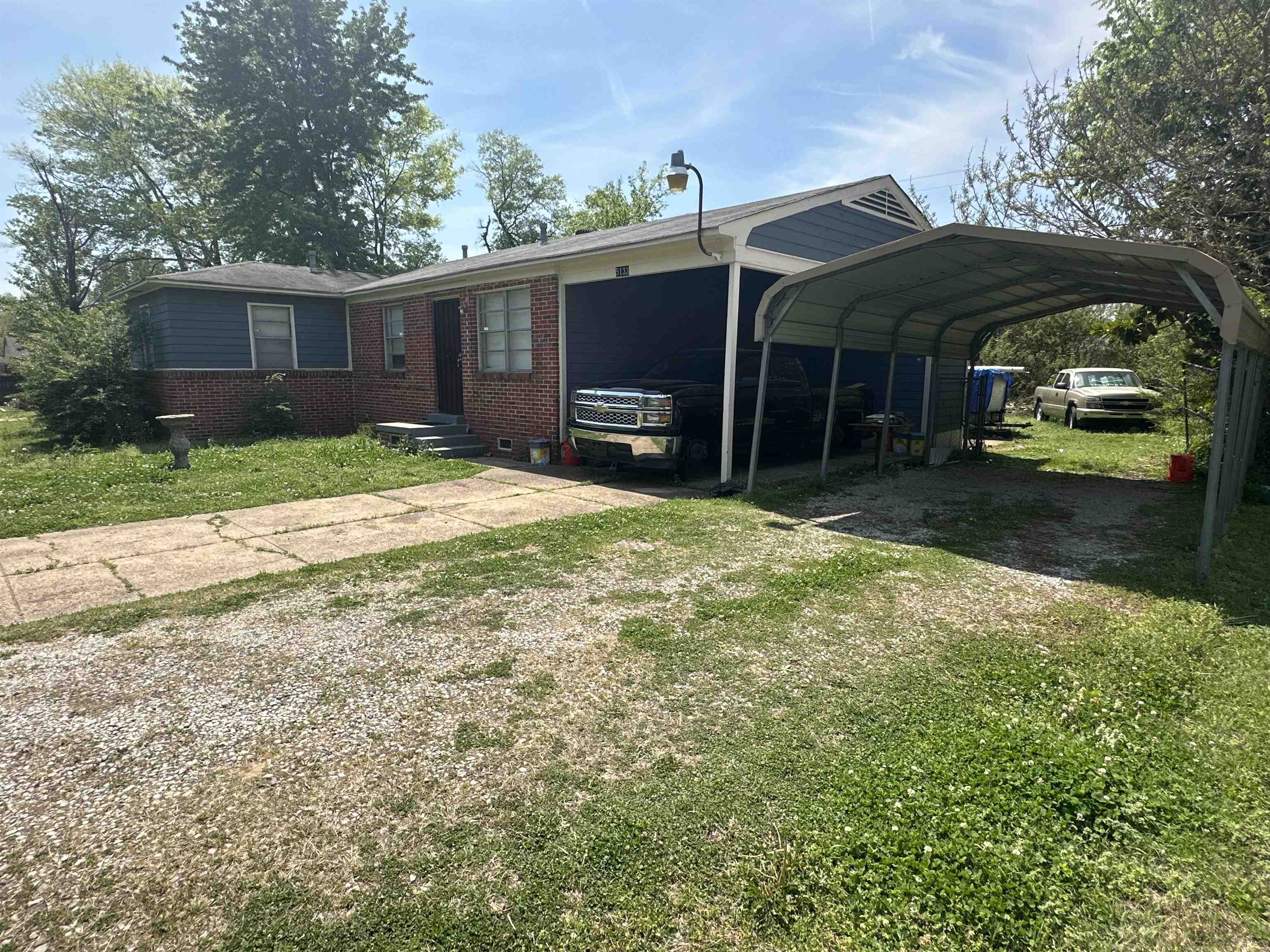 5133 Stacey Road Memphis, TN 38109 - Photo 6 of 10 View of front of property featuring a front yard, driveway, brick siding, and a detached carport
