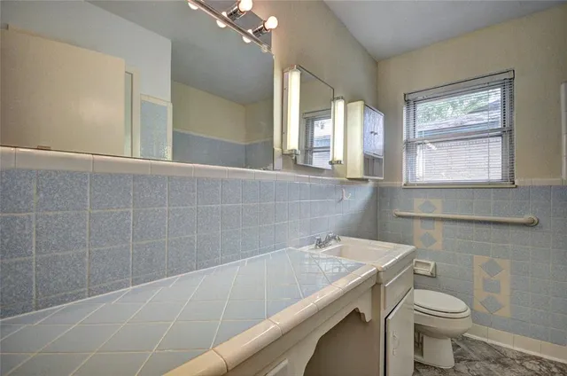 an empty room with windows and fireplace