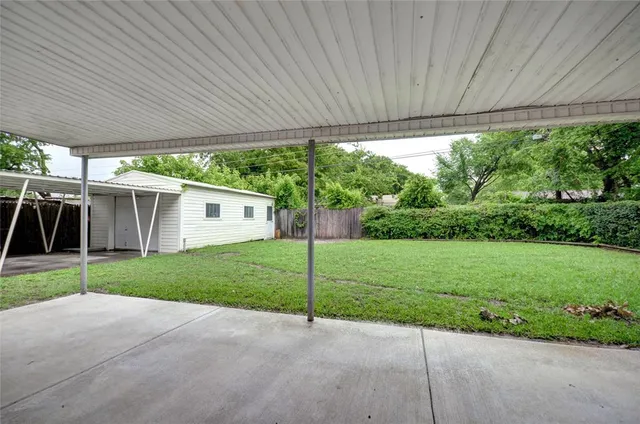 front view of a house with a yard and large trees