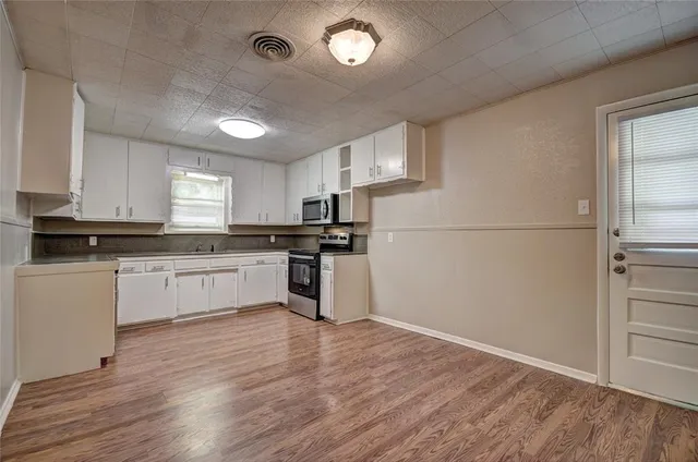 a kitchen with stainless steel appliances granite countertop a stove a sink and a microwave