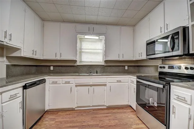 a kitchen with granite countertop cabinets stainless steel appliances and a sink