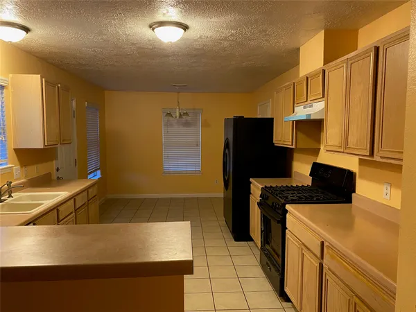a kitchen with a sink a stove top oven a refrigerator and a sink