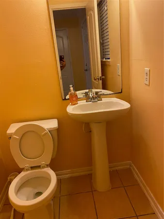 a bathroom with a sink mirror and toilet