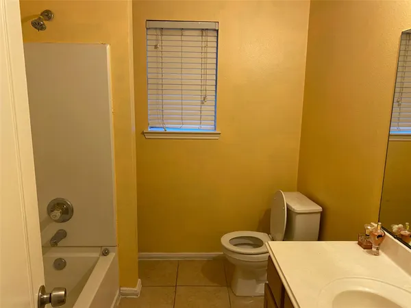 a bathroom with a granite countertop sink and a toilet
