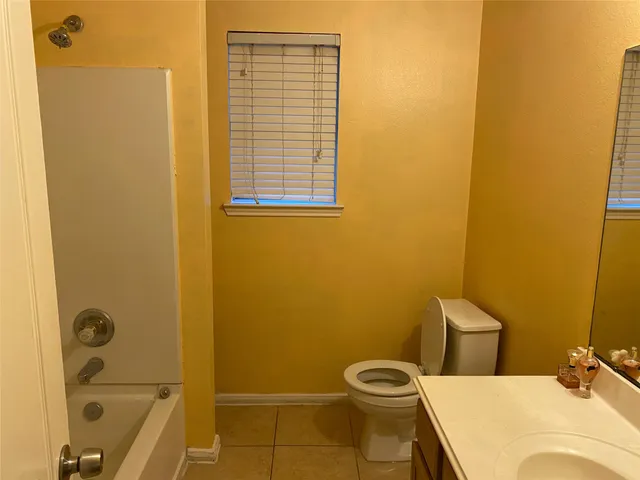 a bathroom with a granite countertop sink and a toilet