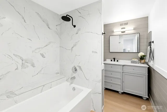 a bathroom with a bathtub sink and mirror
