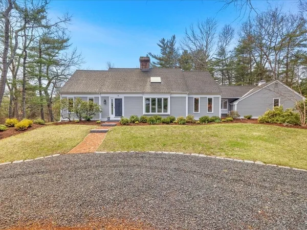 a view of house with yard and large trees