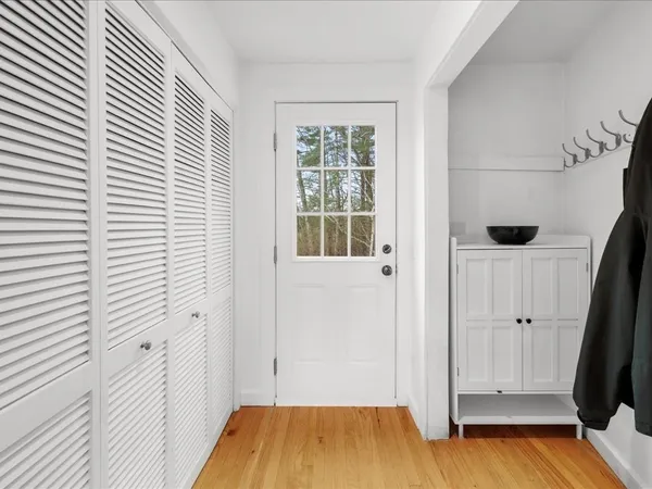 a view of a hallway with wooden floor and a window