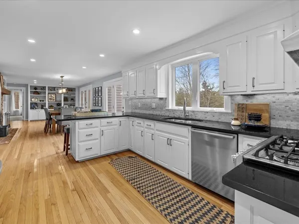 a kitchen with granite countertop a stove a sink and a cabinets