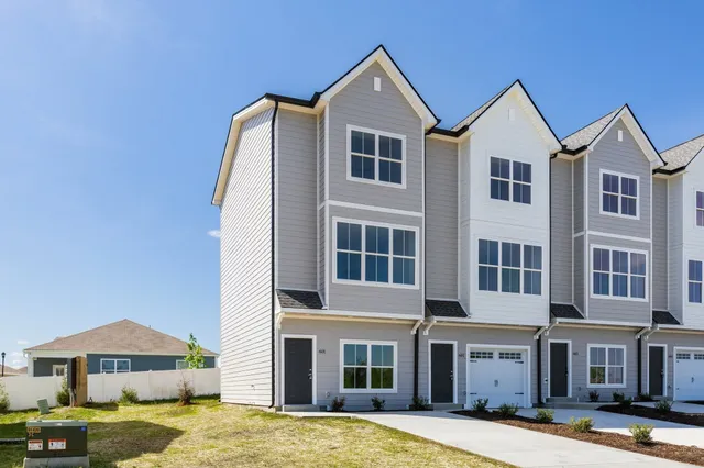 a front view of a building with a garden and plants