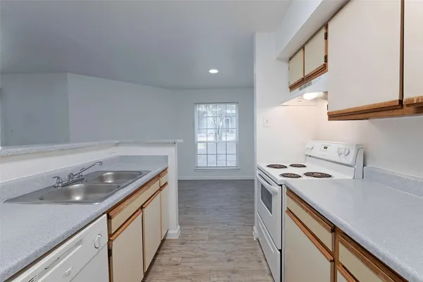 a kitchen with a sink stove and cabinets