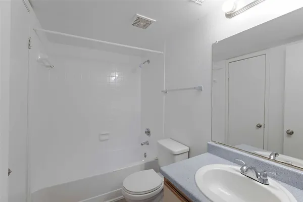 a bathroom with a toilet a sink a mirror and vanity