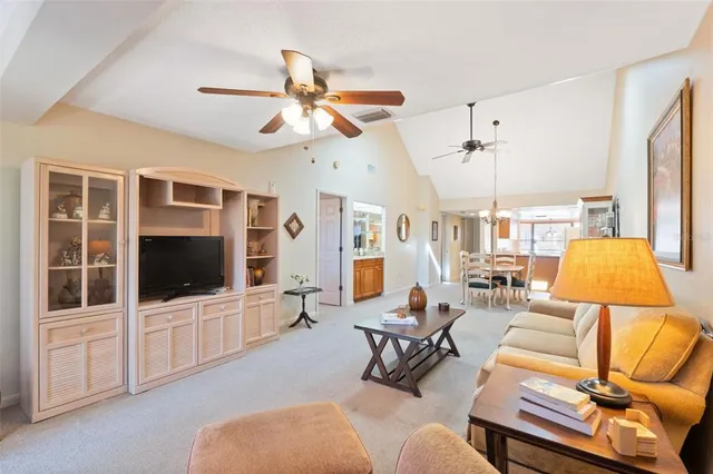 a living room with furniture a flat screen tv and a chandelier