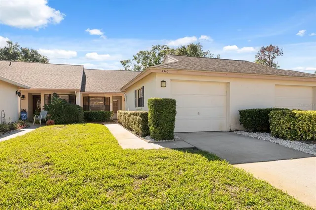 a view of a white house with a yard and potted plants