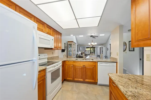 a kitchen with stainless steel appliances granite countertop a sink and a refrigerator
