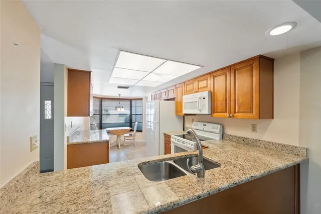 a kitchen with granite countertop a sink and a refrigerator