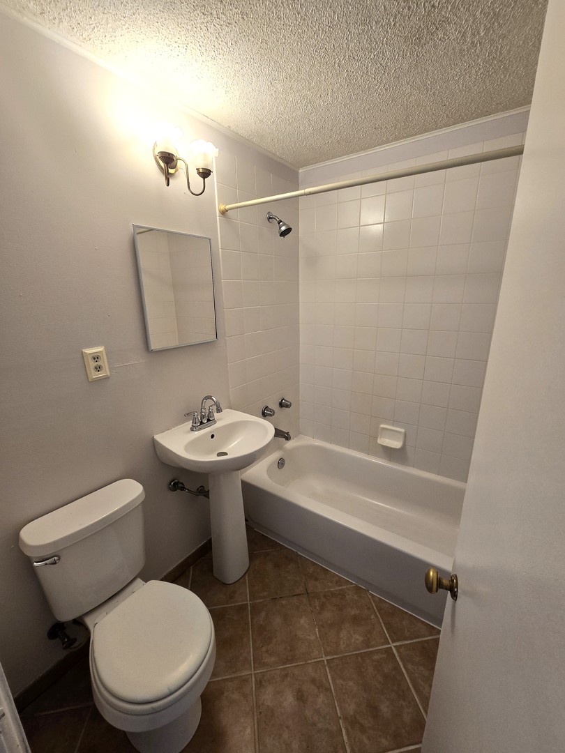 1316 South Fleming Road, Unit A Woodstock, IL 60098 - Photo 14 of 18 a white toilet sitting next to a bathroom sink