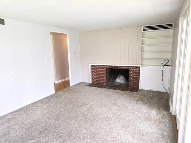 a view of empty room with a fireplace