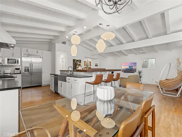 a kitchen with stainless steel appliances kitchen island granite countertop a table chairs and a view of living room