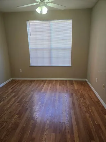 a view of a room that has wooden floor and a window
