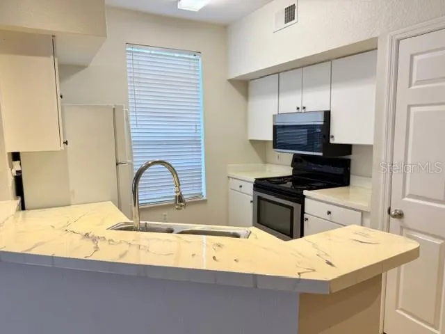 a kitchen with a sink stove and refrigerator