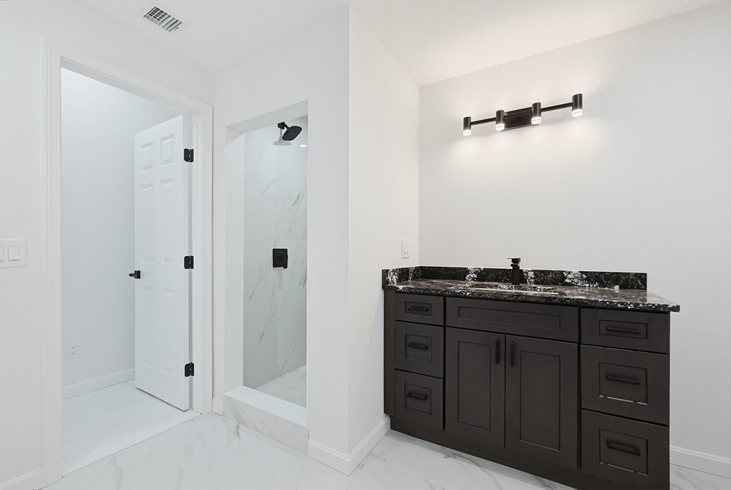 175 Pleasant Street Upton, MA 01568 - Photo 34 of 39 a bathroom with a granite countertop sink a mirror and shower