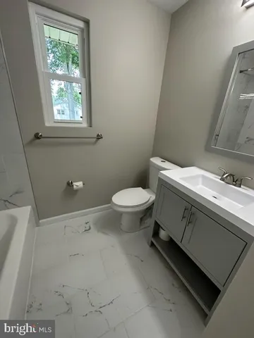 a bathroom with a sink toilet and window