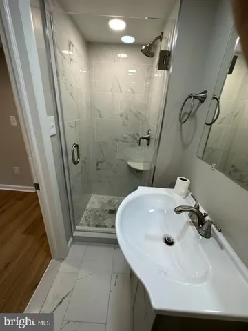 a bathroom with a sink a toilet a mirror and shower